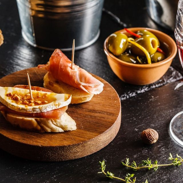 pinchos de jamon, aceitunas y copa de vino